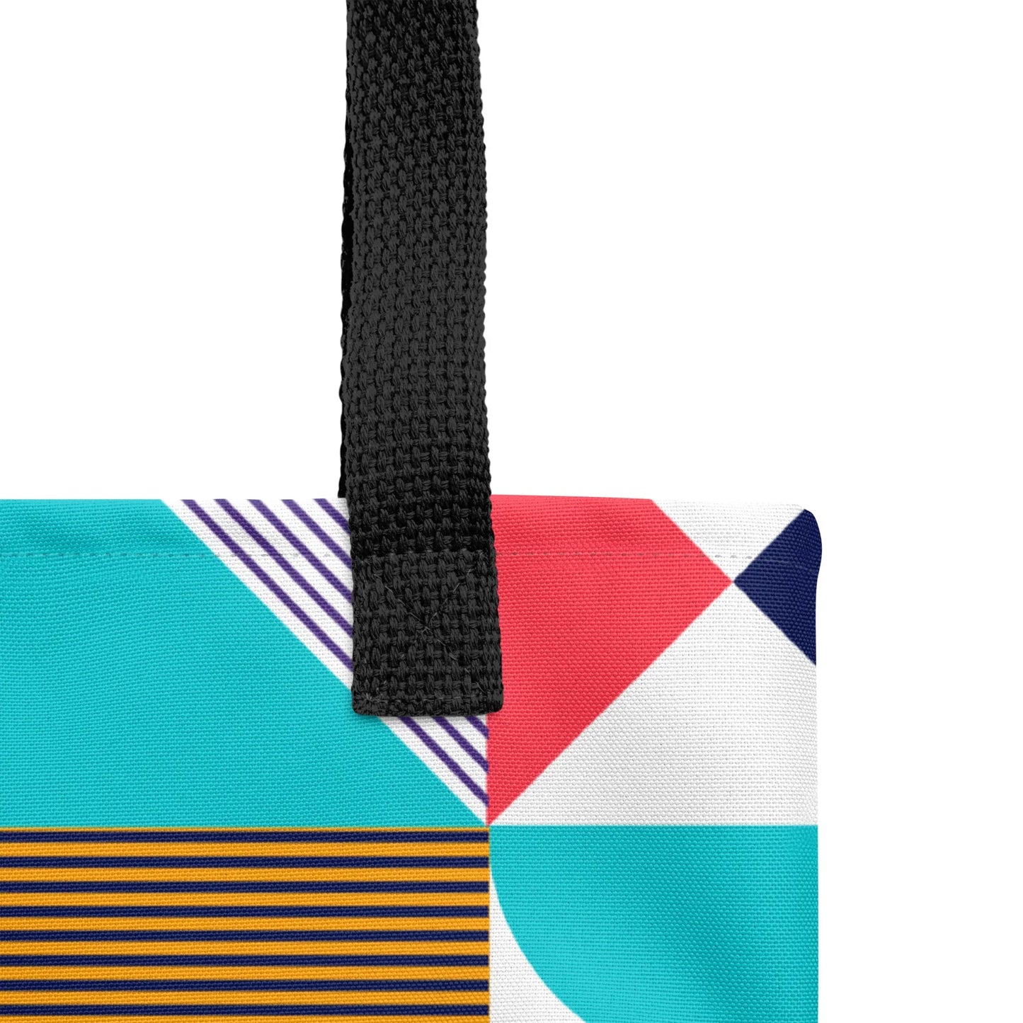 Optimism Tote Bag - Close up of a black handle of a vibrant tote bag featuring a colorful, abstract pattern on its surface. With the word KIND in the centre.